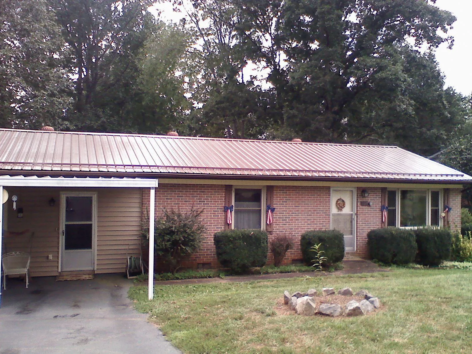 Bronze metal roof and carport on a brick ranch home — Roof Repair work by our crew in Willamina